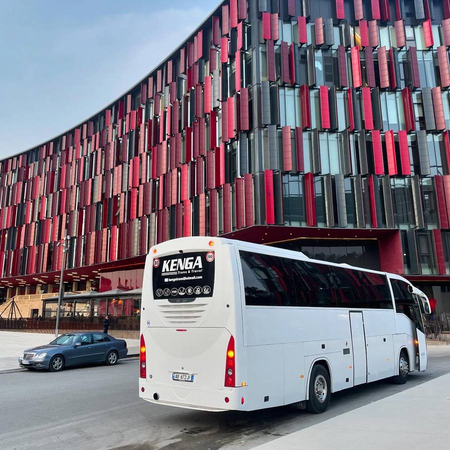 Autobus i bardhë i Kenga Bus i parkuar para Stadiumit Air Albania në Tiranë