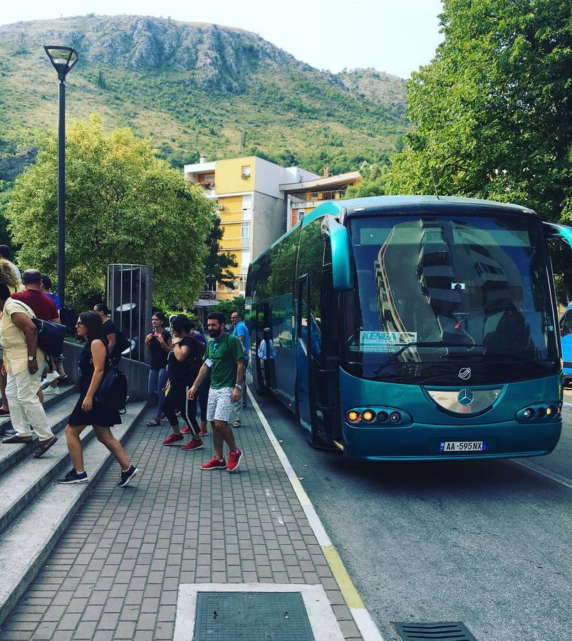 Grup turistësh duke zbritur nga autobusi i Kenga Bus në një qytet malor
